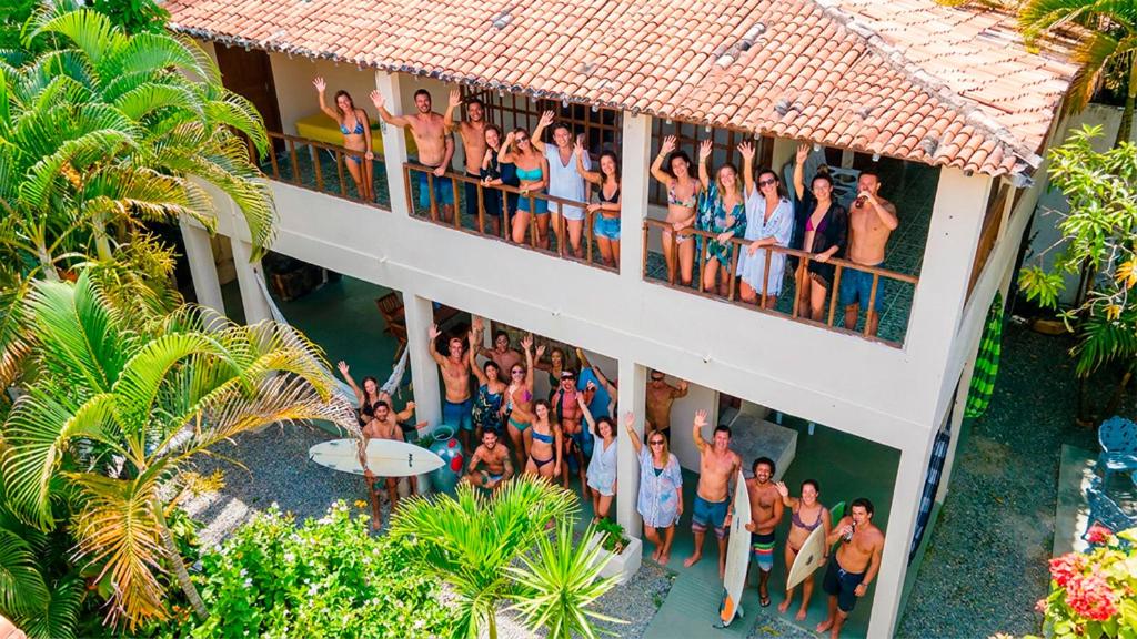 a group of people standing on the balcony of a building at Pipa Surf House in Pipa