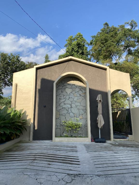 a building with a door and an umbrella at Defano Villa Klotok in Yogyakarta
