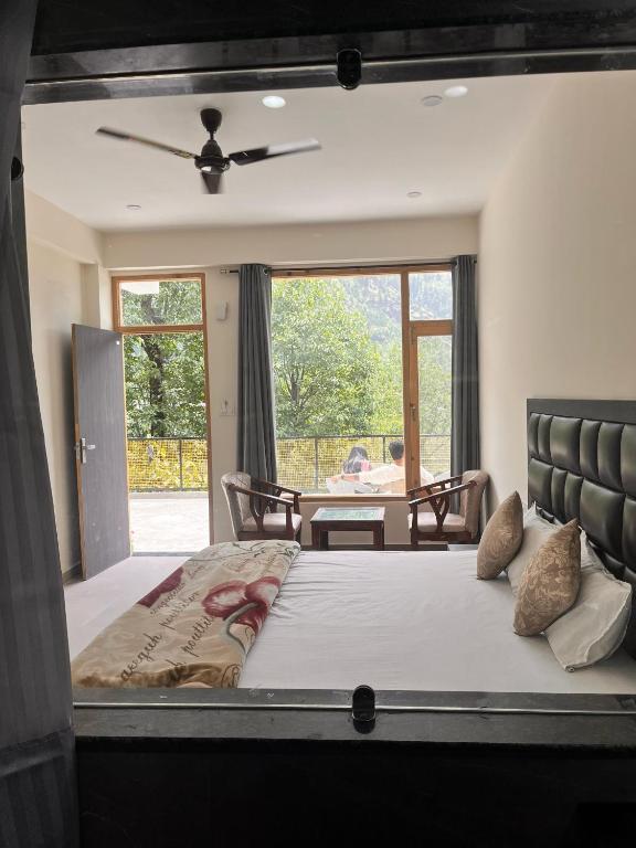 a bedroom with a large bed and a table at Nomad House in Manāli