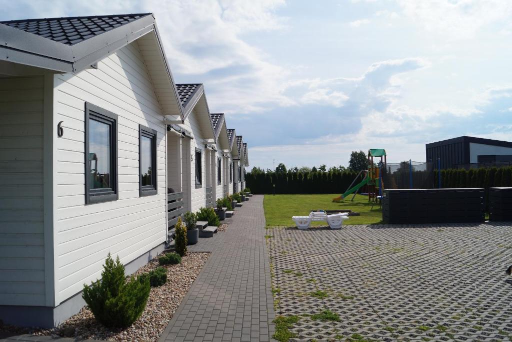 a row of houses with a playground in the background at SŁONECZNE DOMKI in Gąski