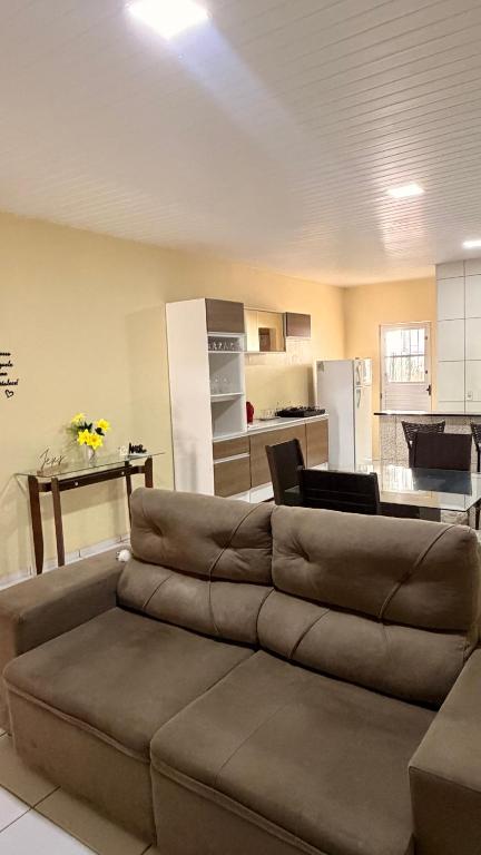 a living room with a couch and a kitchen at Casa Espaçosa e Aconchegante com 4 camas, 3 quartos in Juazeiro do Norte