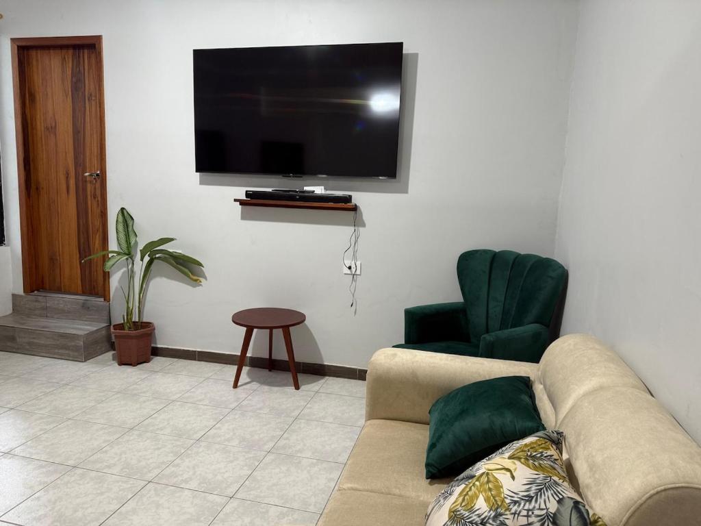 a living room with a couch and a flat screen tv at ACOGEDOR DEPa CON GARAGE PRIVADO in Nueva Loja
