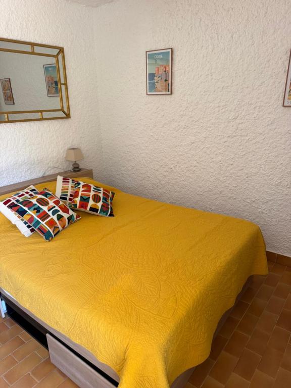 a bedroom with a yellow bed in a room at Cassetta 92 Marie-Pierre in Lumio
