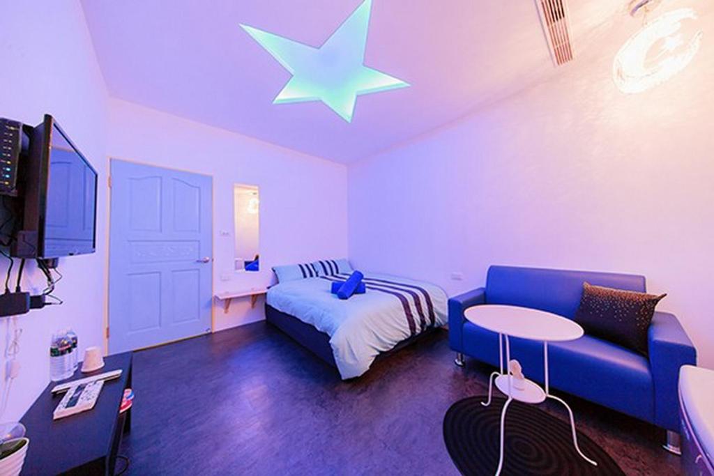 恆春的住宿－ZL民宿，一间卧室配有蓝色的沙发,天花板上有一星星