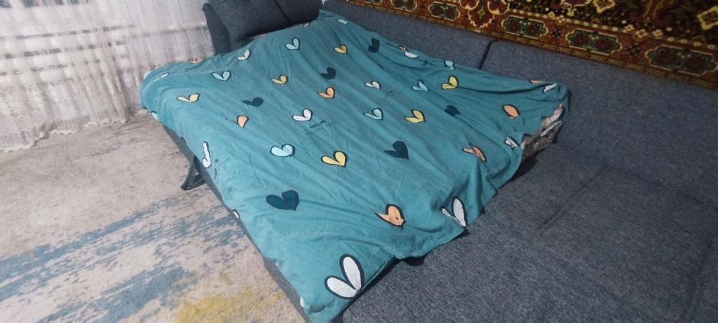 a bed with a blue cover with hearts on it at Alima in Ottuk