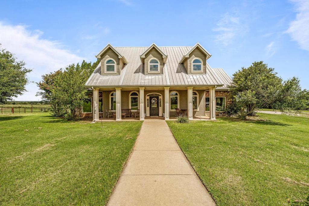 a large house with a grass yard and a sidewalk at Crooked F Ranch in Stephenville