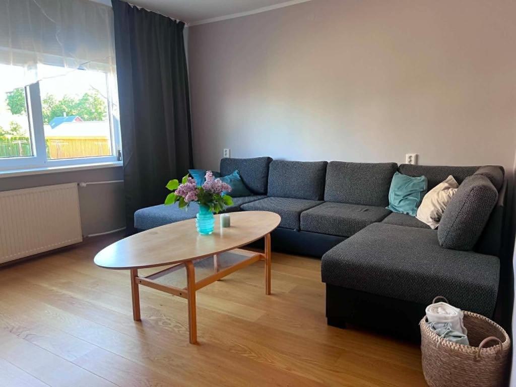 a living room with a couch and a table at Viskoosa Näkmani Apartment in Kõrgessaare