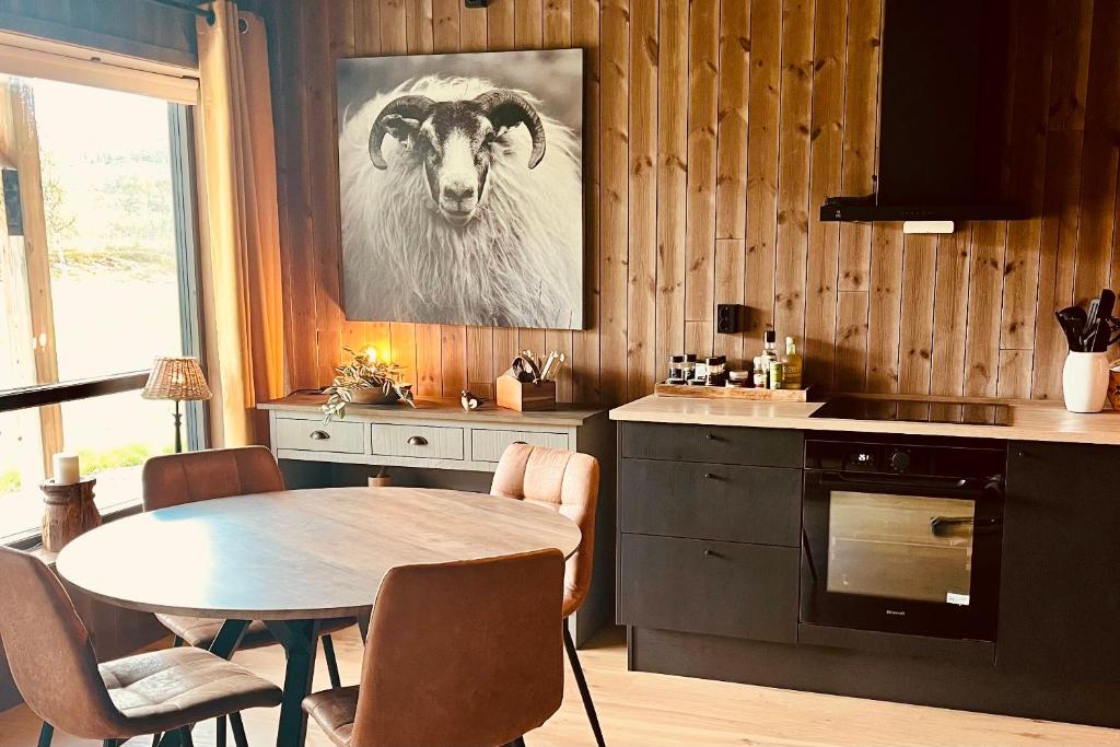 a kitchen with a table and a goat on the wall at New! Mountain apartment close to Hardangervidda in Eidfjord