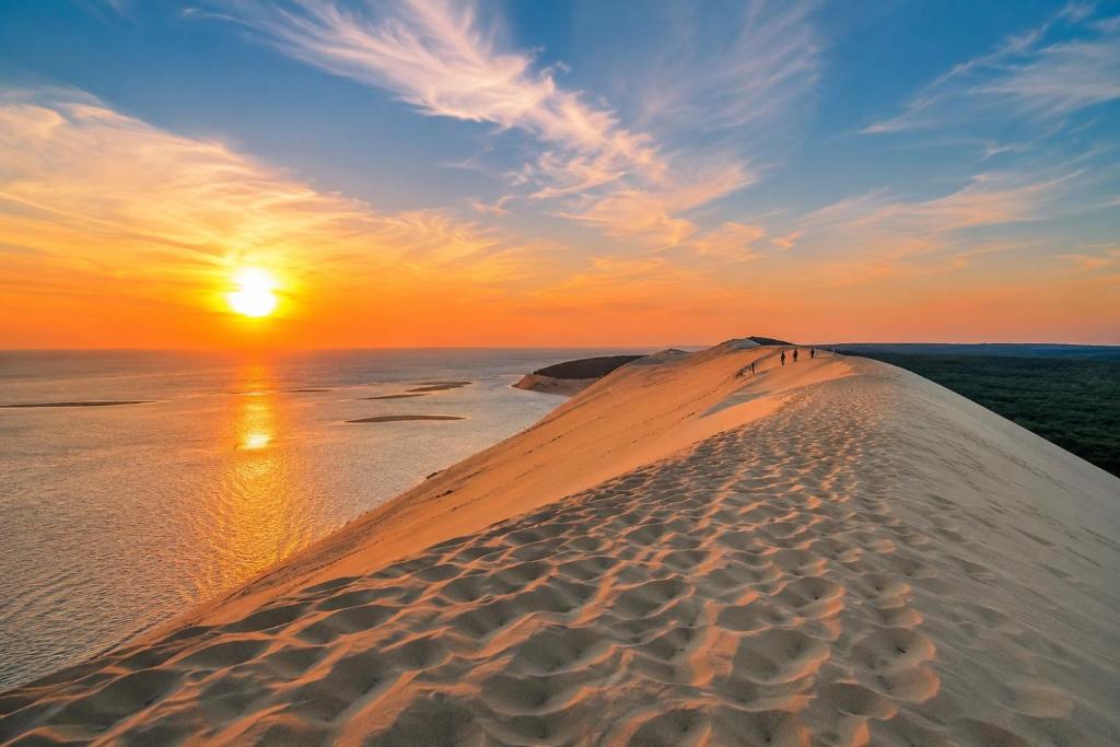 a sunset over a sand dune in the ocean at Apprt la teste de buch in La Teste-de-Buch
