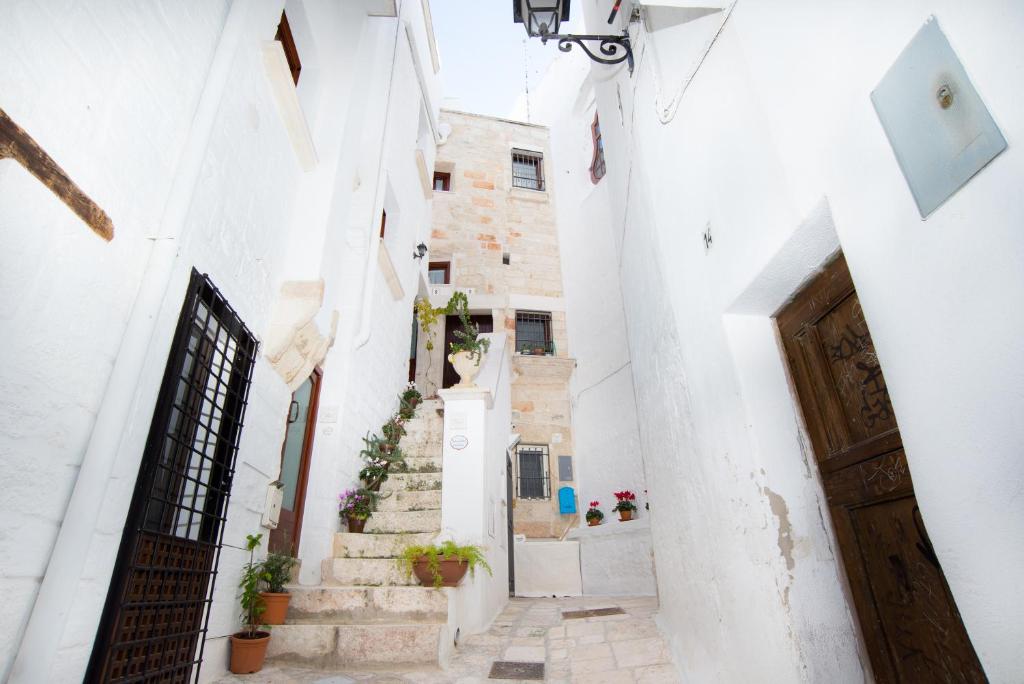 an alley with white buildings and a door at C'era una Volta Apartments in Polignano a Mare