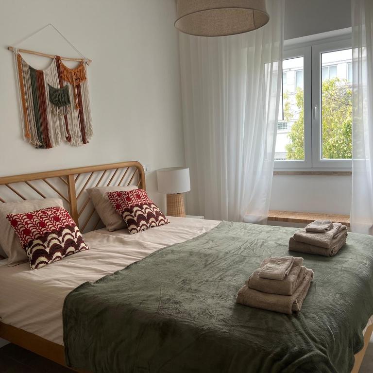 a bedroom with a large bed with two towels on it at Tavira Central Harmony in Tavira
