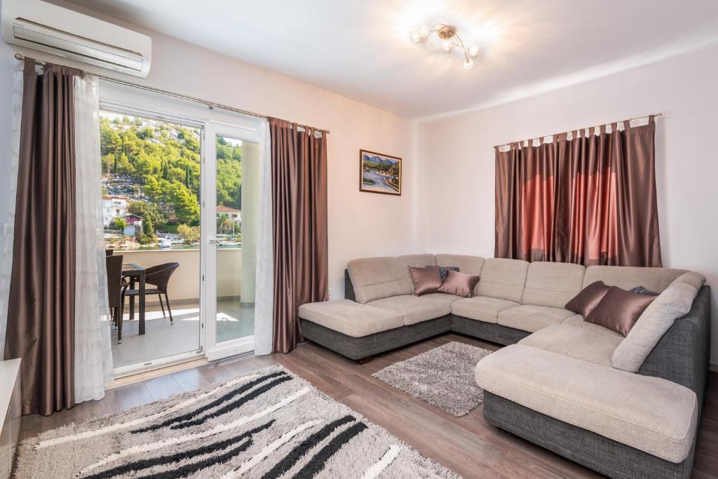 a living room with a couch and a large window at Margaritum Blace - Seaview Apartment with Balcony in Blace