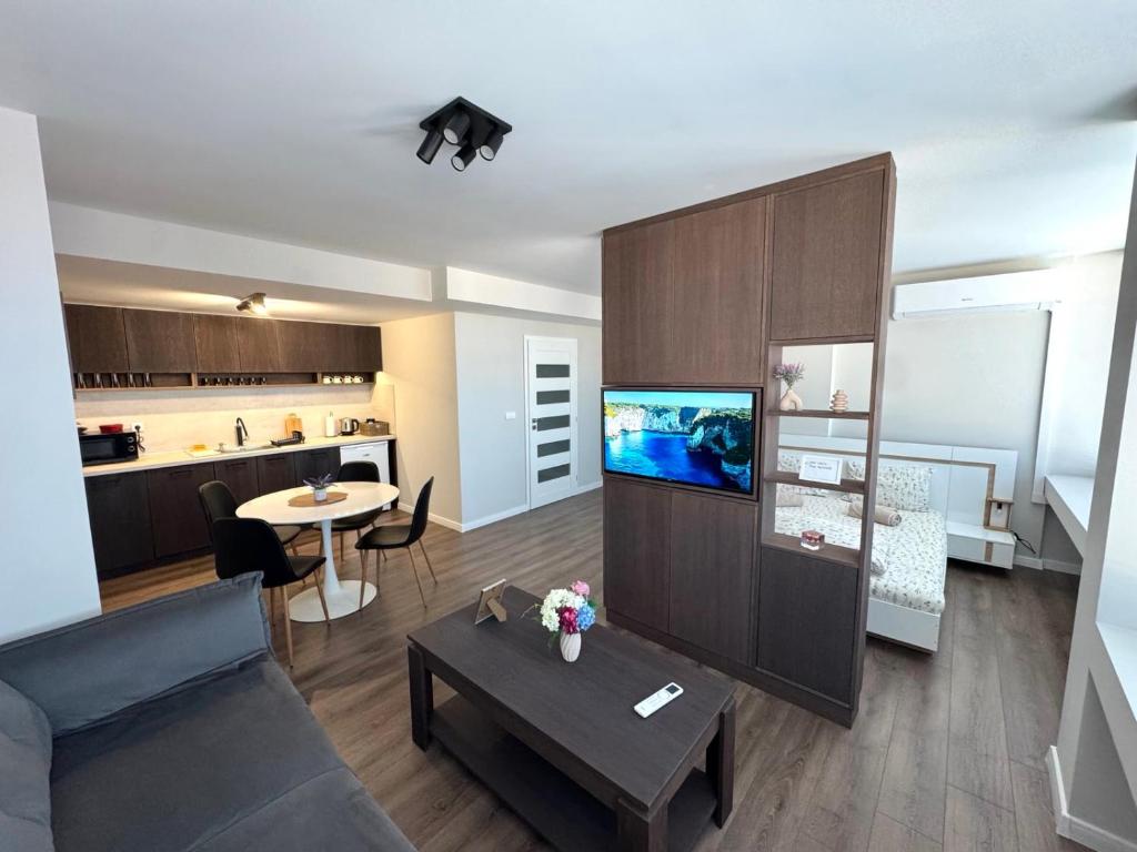 a living room with a couch and a tv and a table at BALKAN TOWER- Apartment Viktoria in Gabrovo