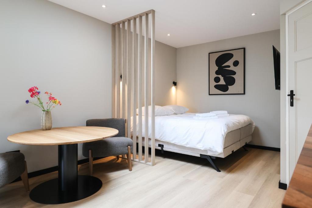 a bedroom with a bed and a table and chairs at City Suite Sneek in Sneek