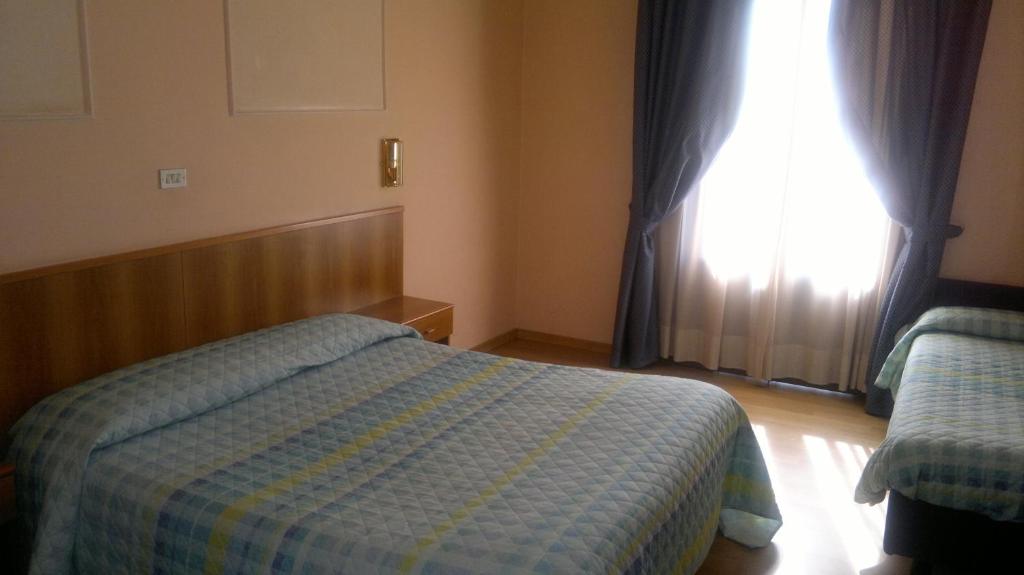 Łóżko lub łóżka w pokoju w obiekcie Hotel Porziuncola