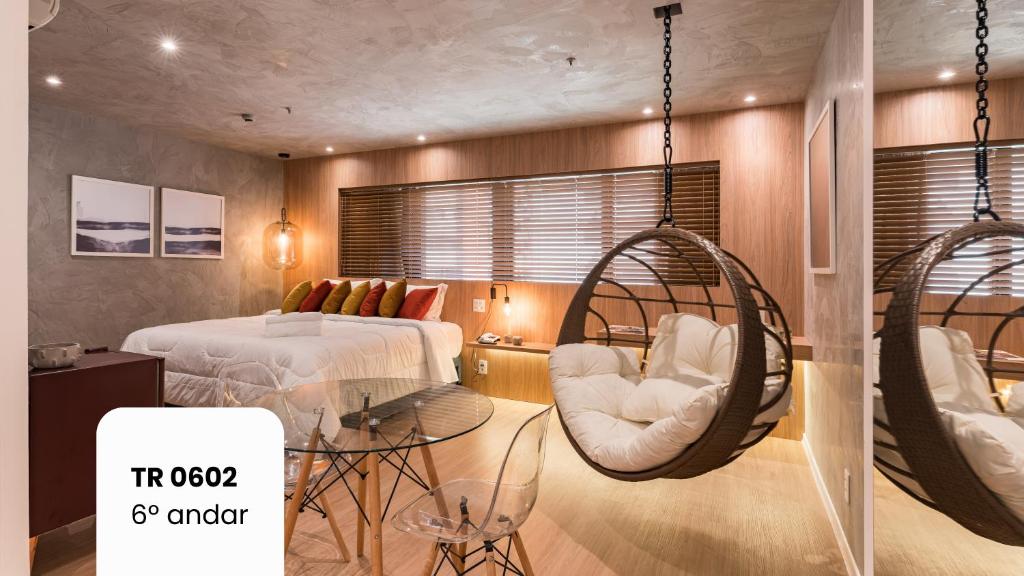 a bedroom with a bed and swing chairs at Cyclinn Faria Lima Itaim in São Paulo