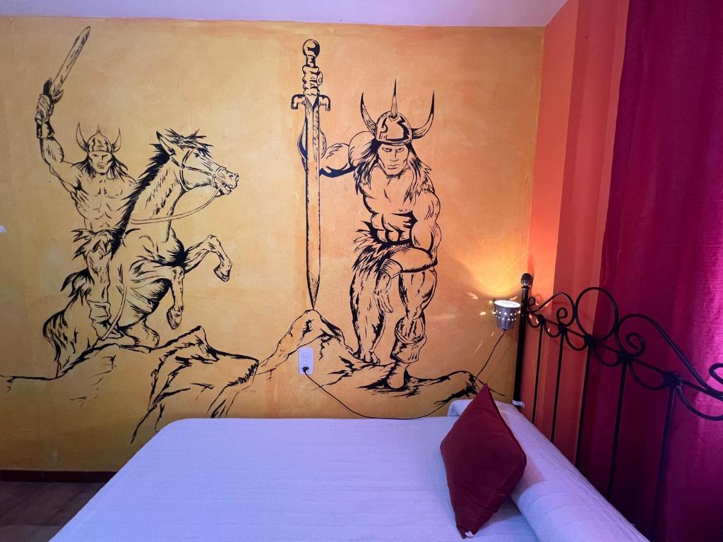 a bedroom with a painting on the wall at Pensión El Alamo in Lepe