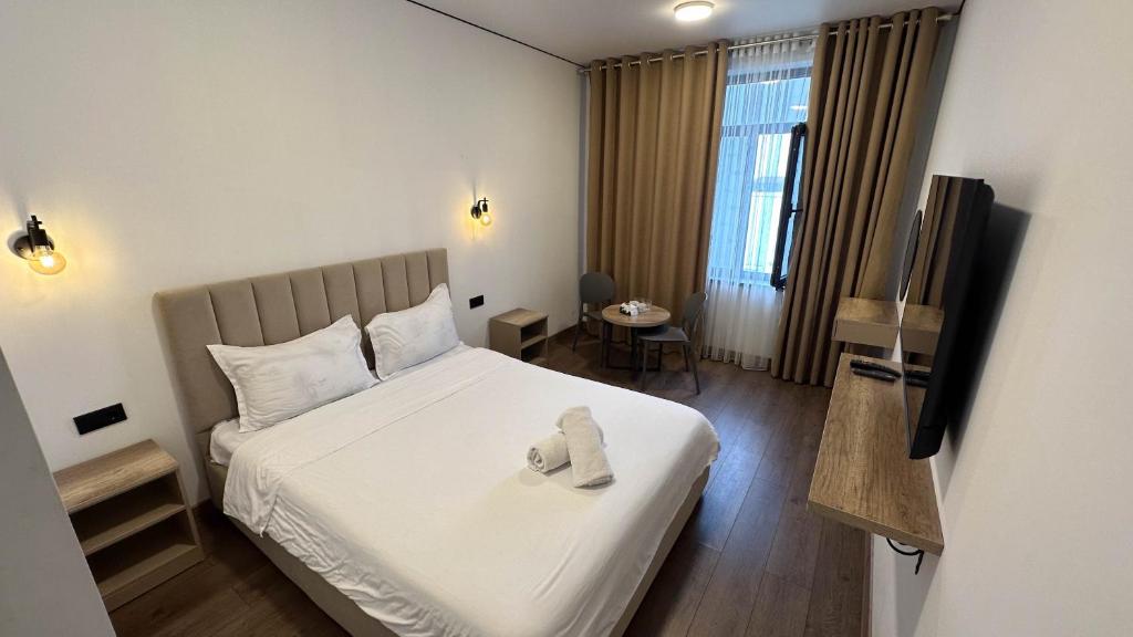 a hotel room with a bed and a television at Тихий Замок Джал in Bishkek