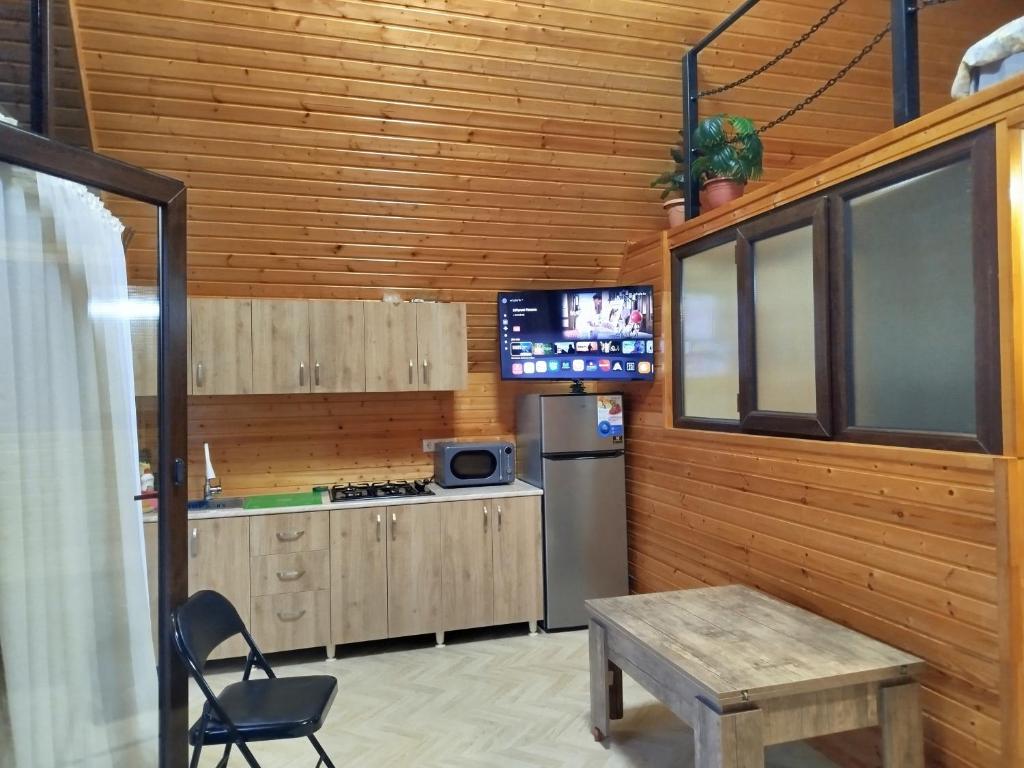 a kitchen with a refrigerator and a table and a tv at Roinis Villa in T'khilnari
