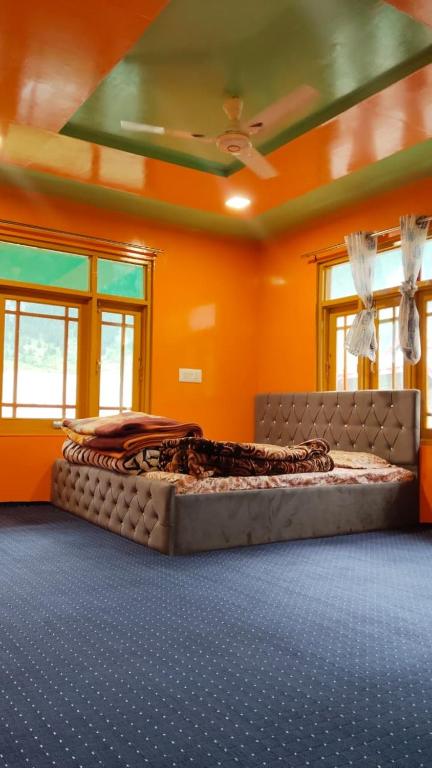 a large bed in a room with orange walls at Samoon guest house in Wāmpor