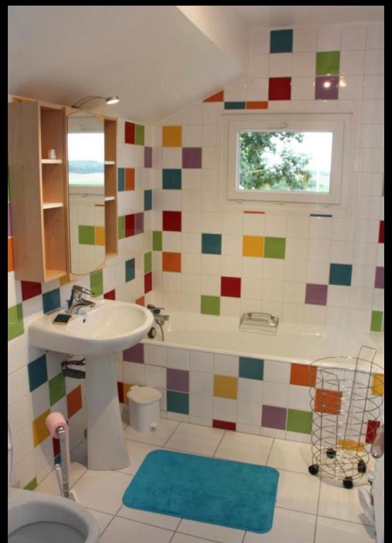 a bathroom with a sink and a toilet and a tub at La Cour des Miracles Gîte in Sequehart