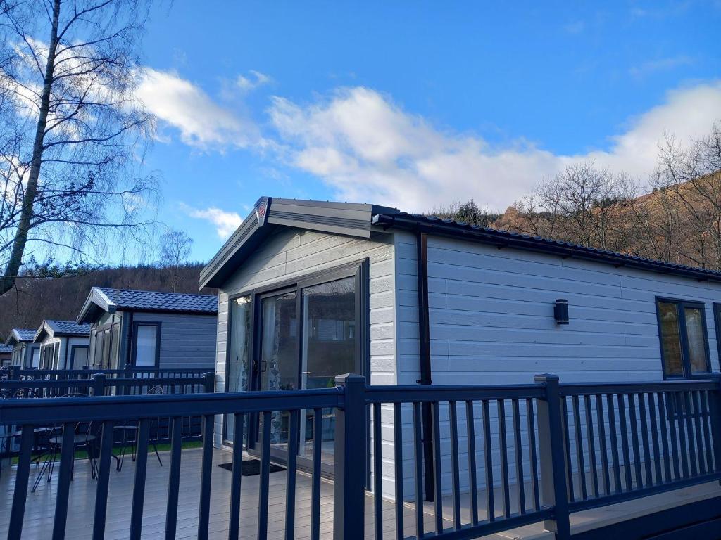 a small house with a fence in front of it at Rowan in Crieff