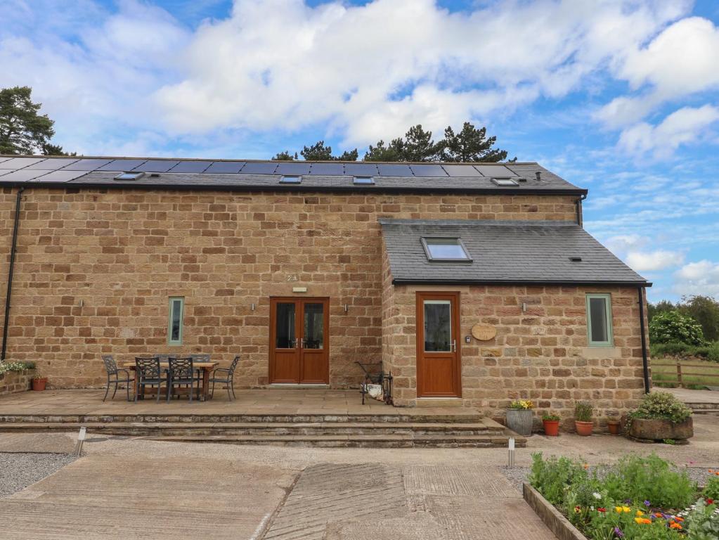 a brick house with solar panels on the roof at Ploughman's Rigg in Harrogate