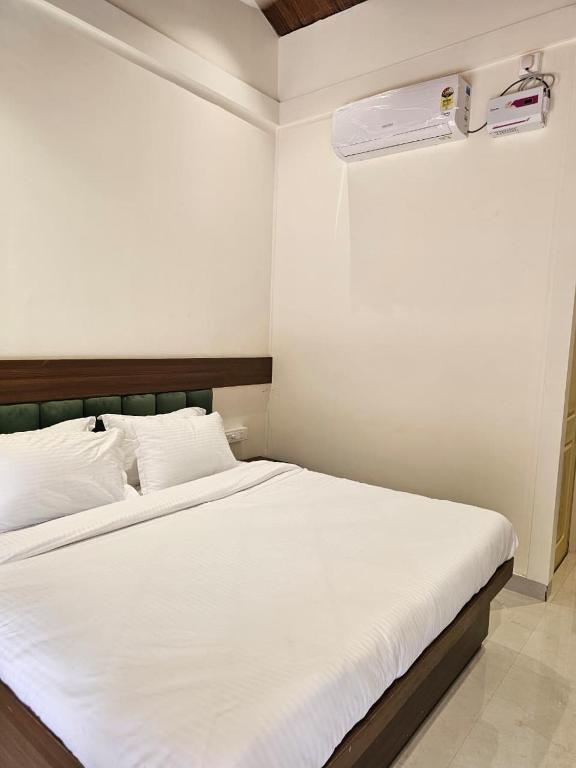 a white bed in a room with at Saavi Resort Shrivardhan in Srīvardhan