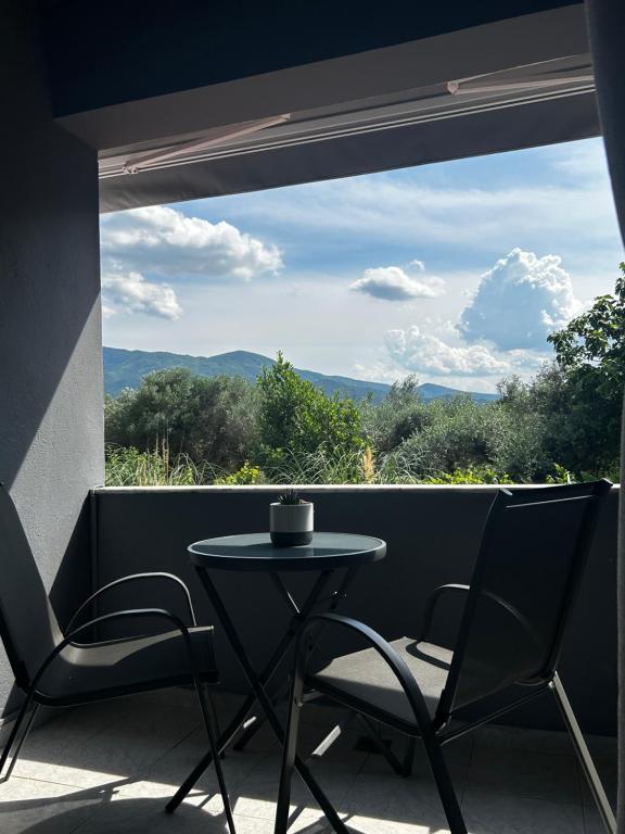 a table and chairs on a balcony with a view at Anna rooms ANTHOS GROUP in Nea Vrasna