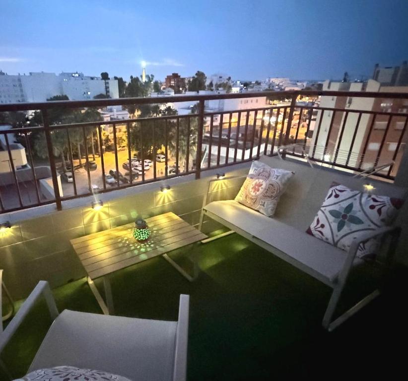 a balcony with a table and chairs on a building at Apartamento SOLYMAR Chipiona in Chipiona