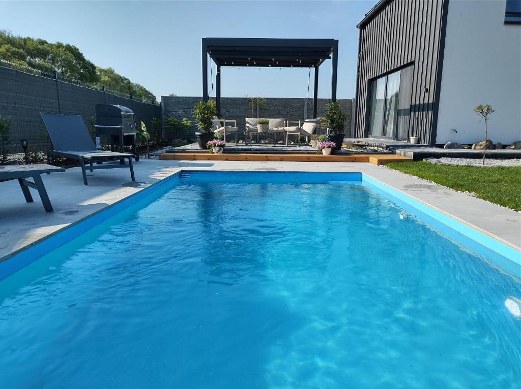a swimming pool with blue water in a backyard at Dovolenkový domček in Sabinov