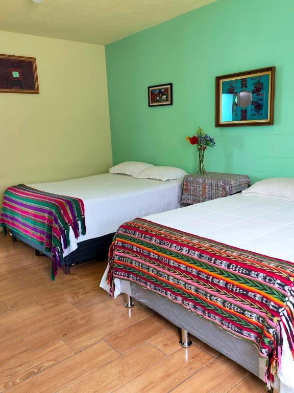 two beds in a room with green walls at Casa Tuta in Ciudad Vieja