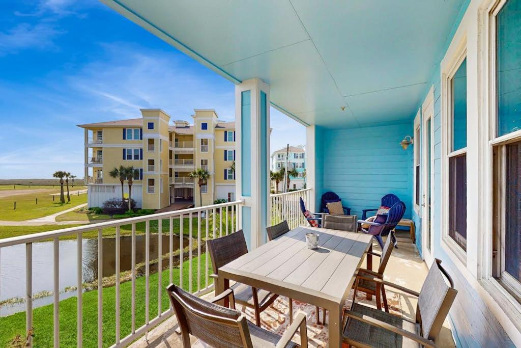 a porch with a table and chairs on a balcony at Point West Resort in Galveston
