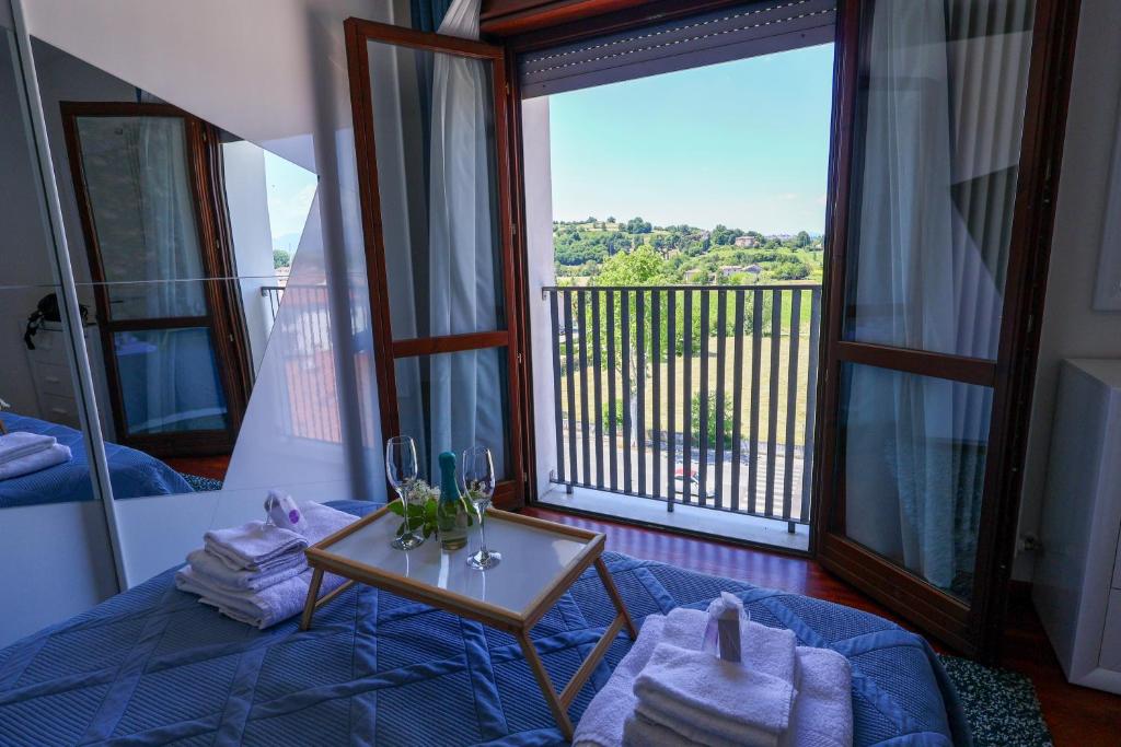 a room with a bed and a table and a balcony at Blu Petrolio Stay-Karabas Apartments-parcheggio in Vicenza