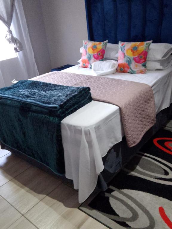 a bedroom with a bed with a blue headboard at Tourist Guest House Accommodation in Mahikeng