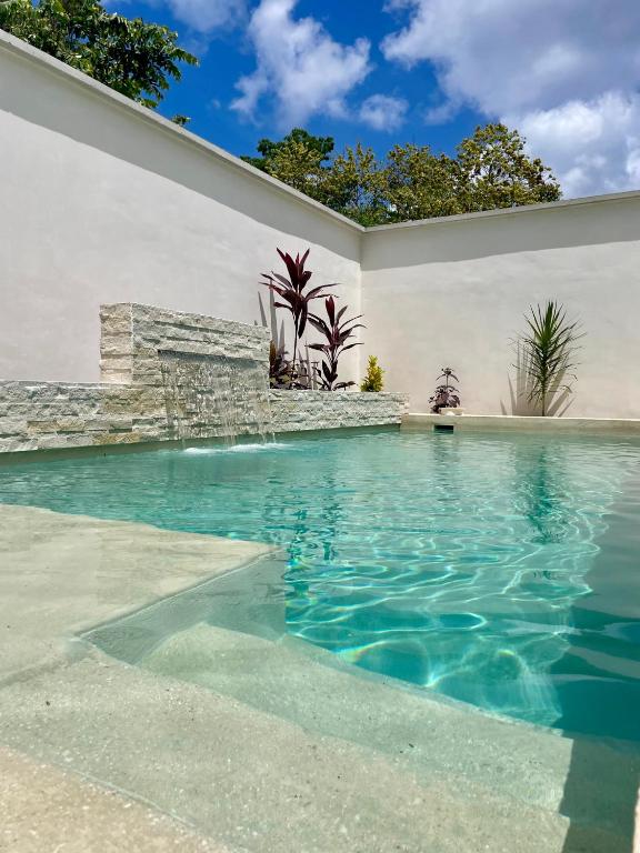 a swimming pool in a house with blue water at Casa Arena Cozumel in Cozumel