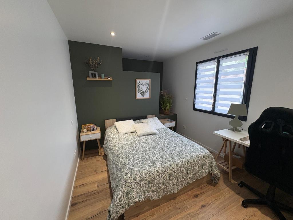 a bedroom with a bed and a desk and a window at Chambre du petit bois in Montceaux