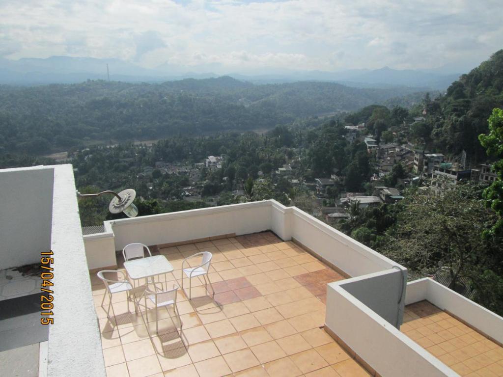 balcón con sillas y vistas al valle en KANDY Holiday Residence, en Kandy