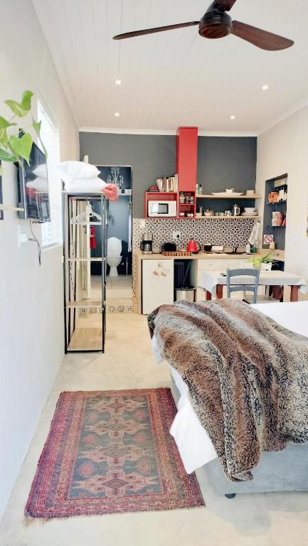 a living room with a bed and a kitchen at Knysna Holiday Cottage in Knysna
