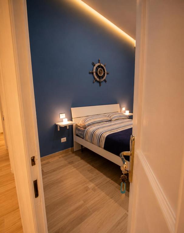 a blue bedroom with a bed and a clock on the wall at Relais Principe Umberto in Naples