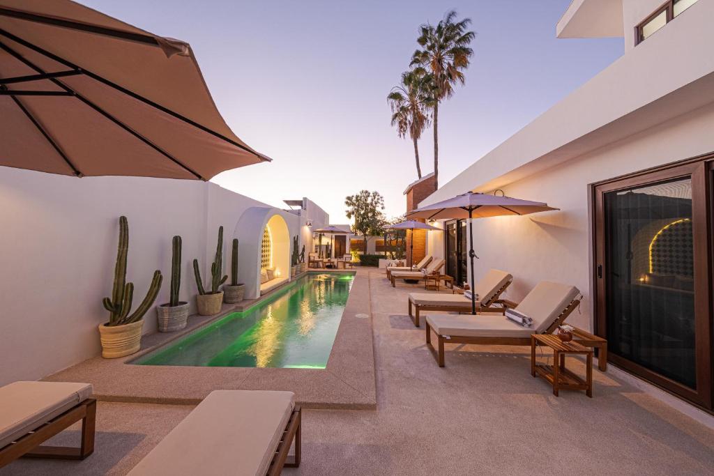 an outdoor swimming pool with chaise lounge chairs and a resort at Abasolo Clubhouse in La Paz