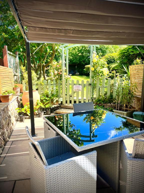 a patio with a table and chairs and a pond at Village Cottage Marple in Marple