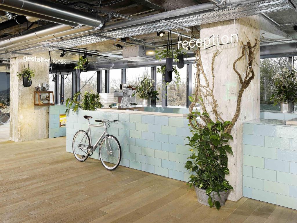 a bike parked next to a counter with plants at 25hours Hotel Bikini Berlin in Berlin