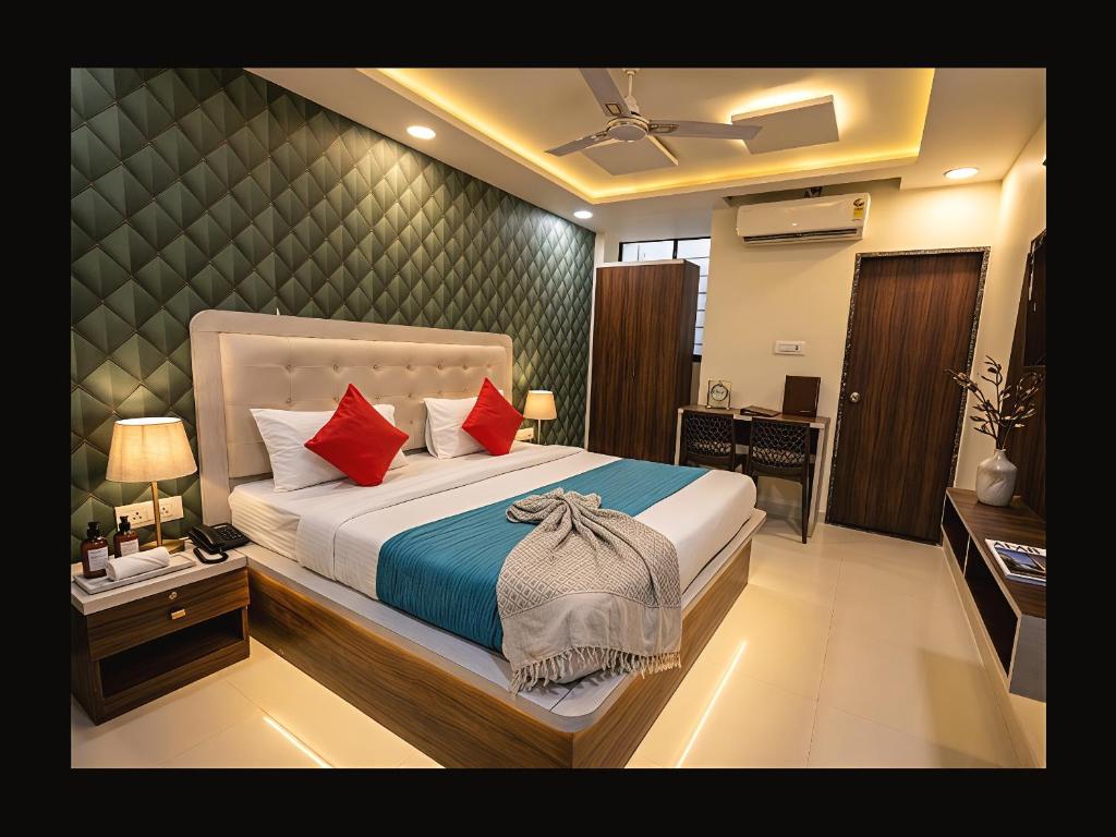 a bedroom with a large bed with red pillows at Hotel Venus Inn in Indore