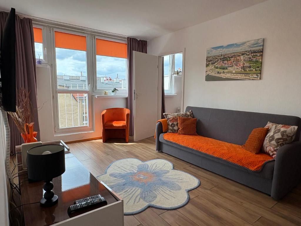 a living room with a couch and some windows at Aleda Kaskada in Szczecin