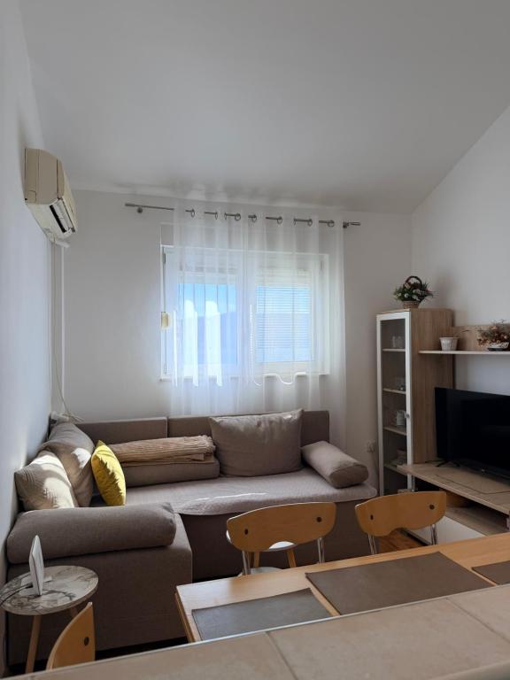 a living room with a couch and a table at Lumier Apartment in Zelenika