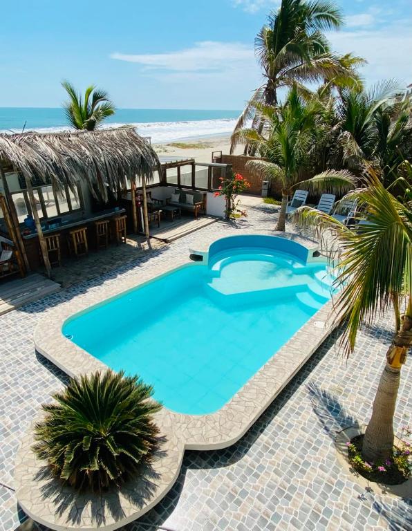 a swimming pool in front of the beach at Hotel Puerto Antiguo in Los Órganos