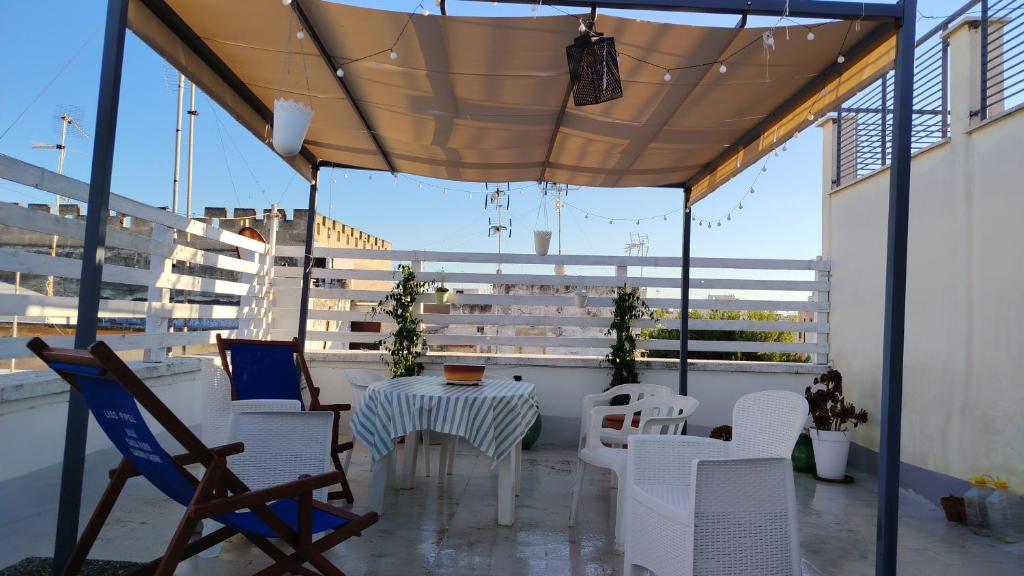 a patio with a table and chairs on a balcony at La Chiocciola in Trani