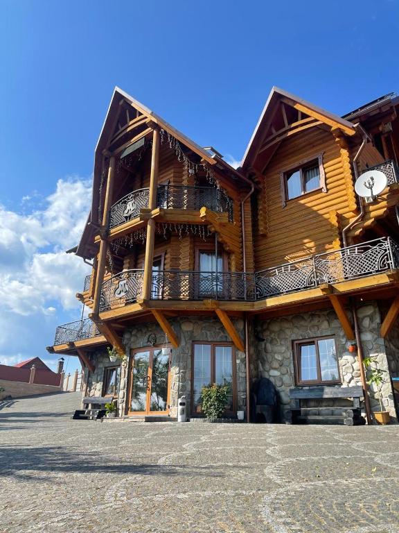 a large wooden house with a balcony on the side at М House in Vorokhta