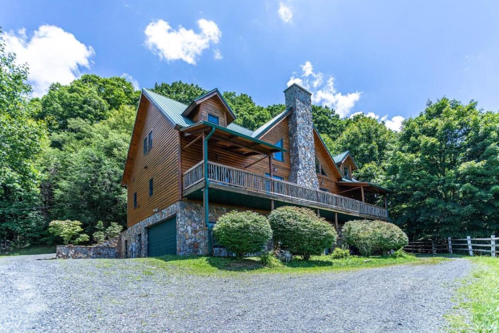 a log home with a balcony on a driveway at Sunset View Lodge in Elk Park